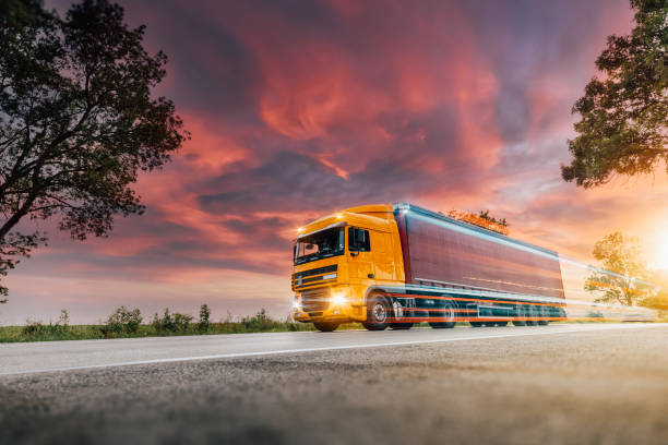Lorry on a motorway in motion Orange Lorry on a motorway in motion near London, United Kingdom truck mode of transport road transportation stock pictures, royalty-free photos & images