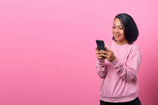 istock Cheerful young Asian using smartphone with smiling face 1335887284