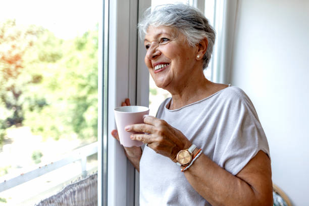 istock Beautiful old lady behind the window. 1335890161