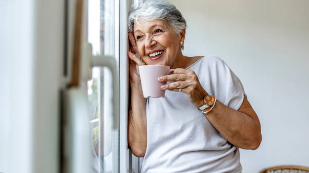 istock Beautiful old lady behind the window. 1335890171