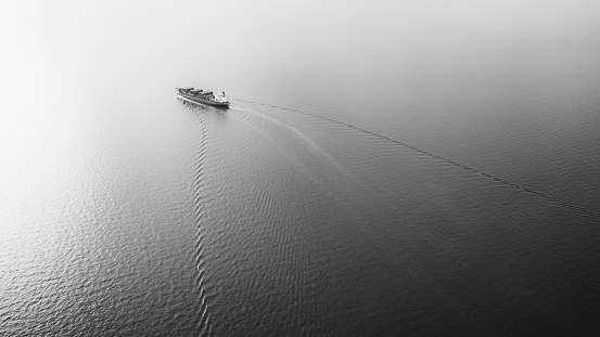 black and white smaller container ship full speed sailing in sea and beautiful streak sea waves background abstract Photograph aerial view from drone