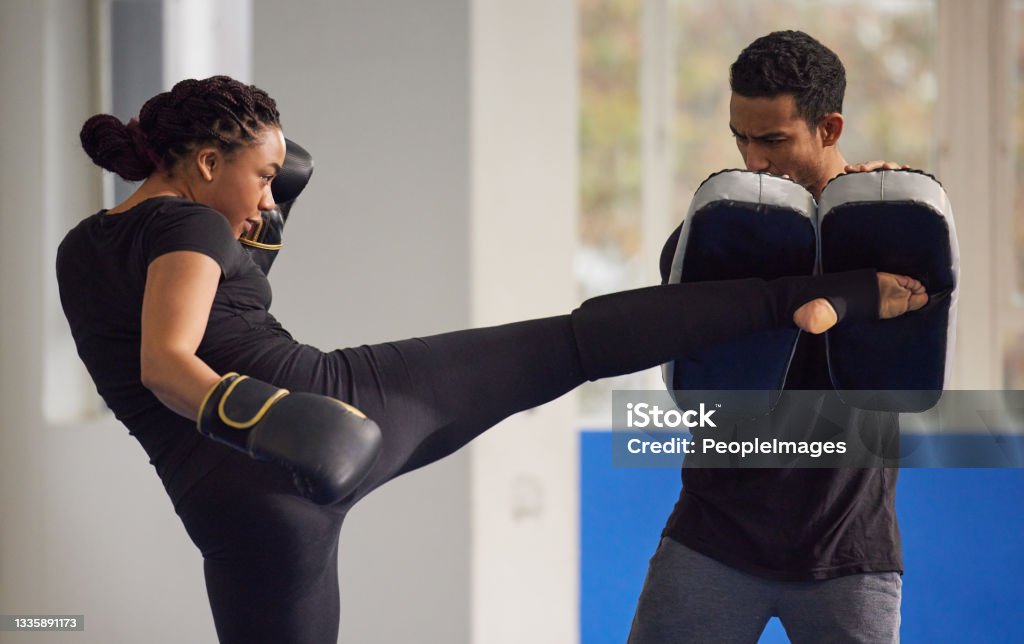 Shot of a young woman practicing kickboxing with her trainer in a gym Kickboxing is the best form of dynamic exercise Kickboxing Stock Photo