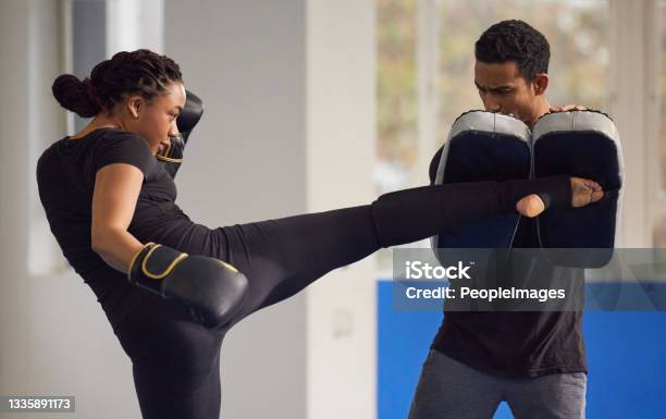 Shot Of A Young Woman Practicing Kickboxing With Her Trainer In A Gym Stock Photo - Download Image Now