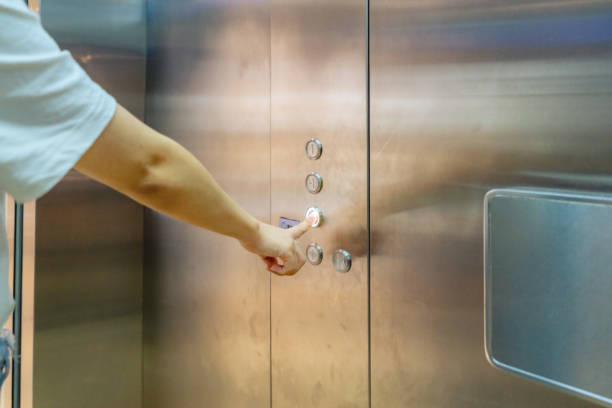 istock A lady in the elevator presses the button on the second floor with her finger 1335892912