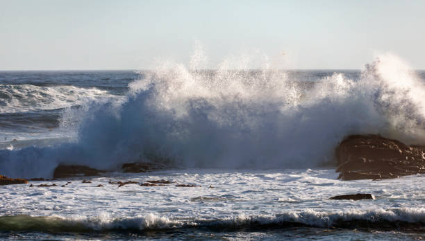 istock High storm wave with foam and spray breaks on the shore. 1335892930