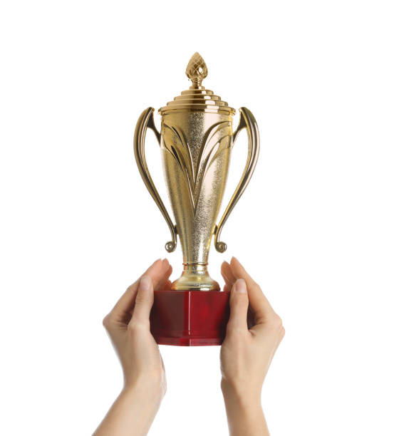 istock Woman holding gold trophy cup on white background, closeup 1335894576