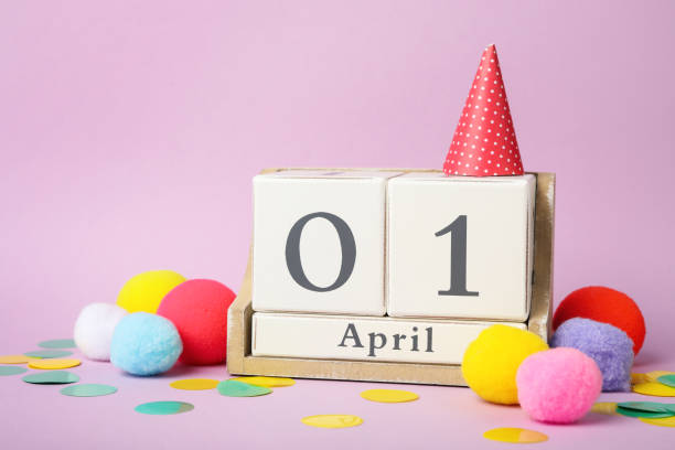 kalendarz z drewnianego bloku i wystrój imprezy na fioletowym tle. prima aprilis - entertainment bright carnival celebration zdjęcia i obrazy z banku zdjęć