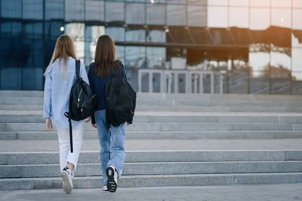 Two teenage student friends girls happy going to college or school