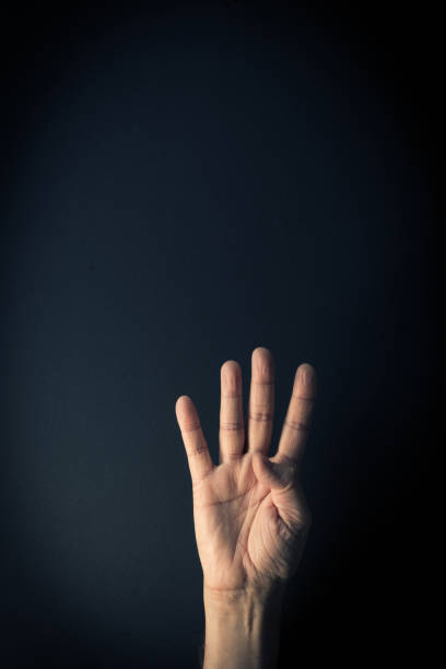 istock Colour image of hand demonstrating sign language number four with background and empty copy space 1335900300