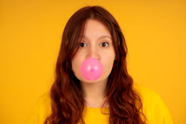 istock Young woman making a balloon with the chewing gum. 1335905157