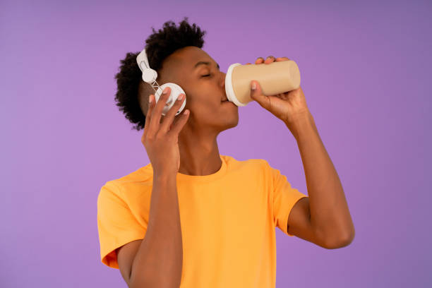 istock Afro man drinking coffee while listening music with headphones. 1335905550