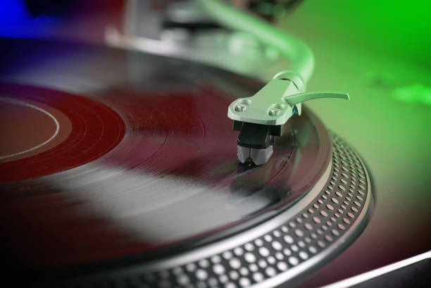 istock close view of a vinyl record playing  on a turntable, colored  lighting 1335906799