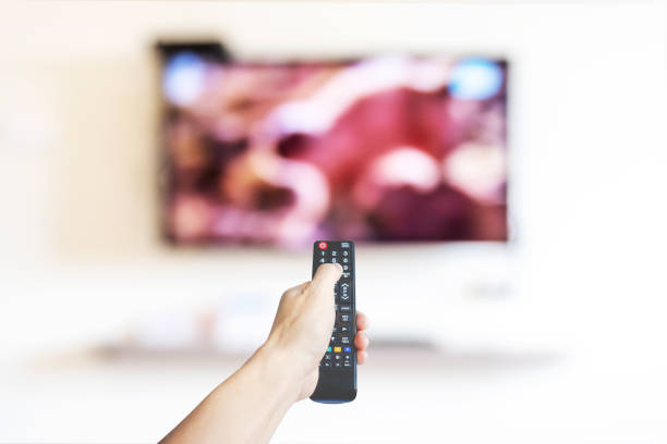 istock Hand holding television and audio multimedia remote control for watching tv 1335909974
