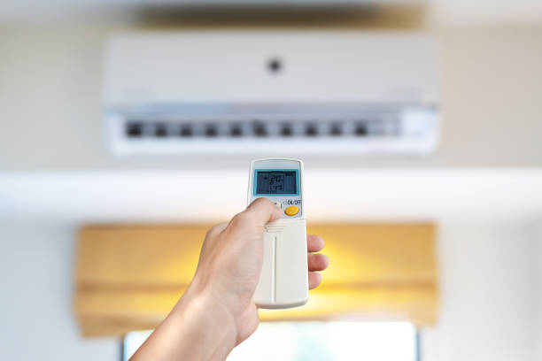 istock Air conditioner inside the room, Man's hand using remote control open The air conditioner in his bedroom. Health concepts and energy savings 1335909989