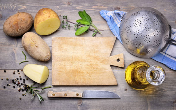 istock Organic potatoes with empty cutting board in vintage setting, Top view, space for text. 1335910434
