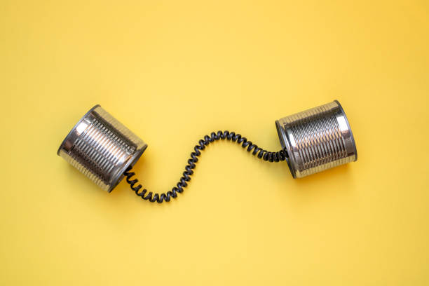 lata pode telefonar em fundo amarelo, conceito de comunicação - communication connection can tin can phone - fotografias e filmes do acervo