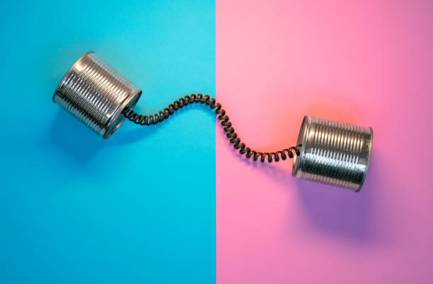 istock Tin can phone on pink and blue paper background, Communication concept 1335910711