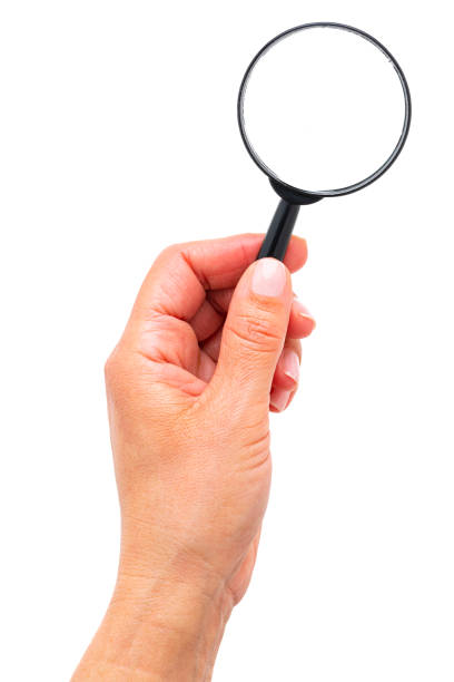 istock Hand holding magnifier glass isolated on white 1335912932