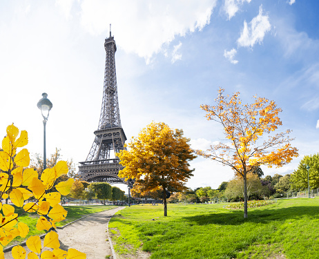 Paris Eiffel Tower with park in Paris, France. Eiffel Tower is one of the most iconic landmarks of Paris at fall with sunshine