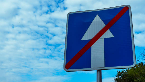 istock Blue road sign end to one way traffic on cludy blue sky background. Space for text. 1335921224