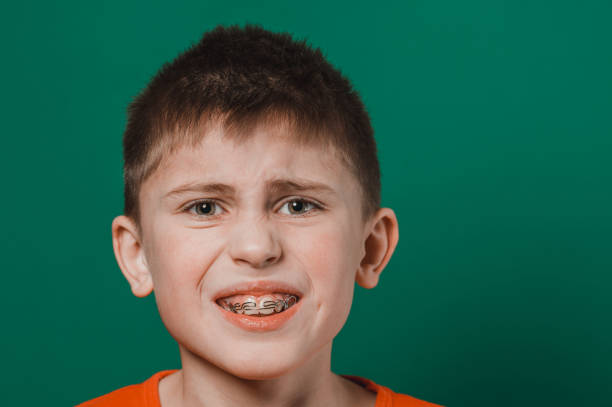 istock A boy on a green background shows his plate for aligning teeth. 1335922256