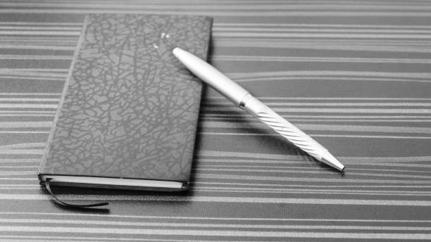 Pen and notebook on office table. Table top view. Corporate business background.