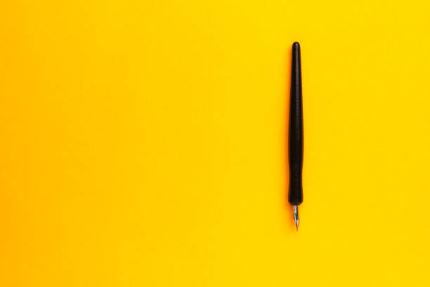istock Pen on a yellow background with a copy space for text 1335927586