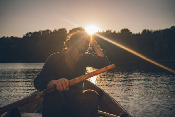 istock View of young man rowing boat down lakeshore 1335928527