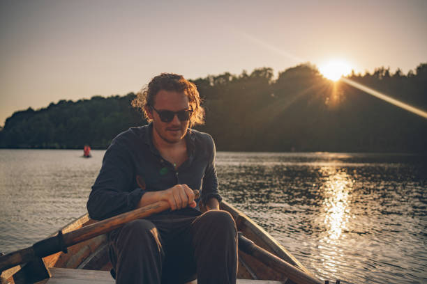 istock View of young man rowing boat down lakeshore 1335928573