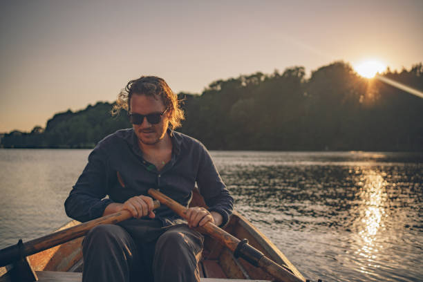 istock View of young man rowing boat down lakeshore 1335928575