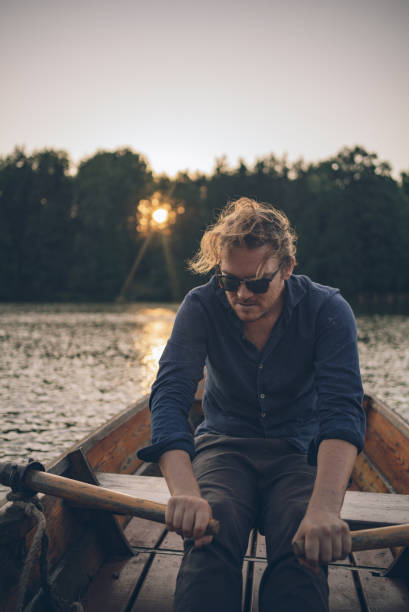 istock View of young man rowing boat down lakeshore 1335928850