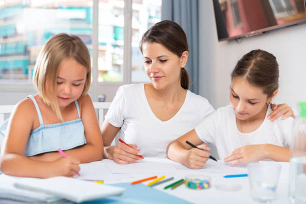istock Young woman and two daughters drawing together 1335932457