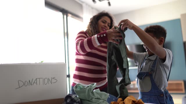 Mother and son sorting clothes for donation at home