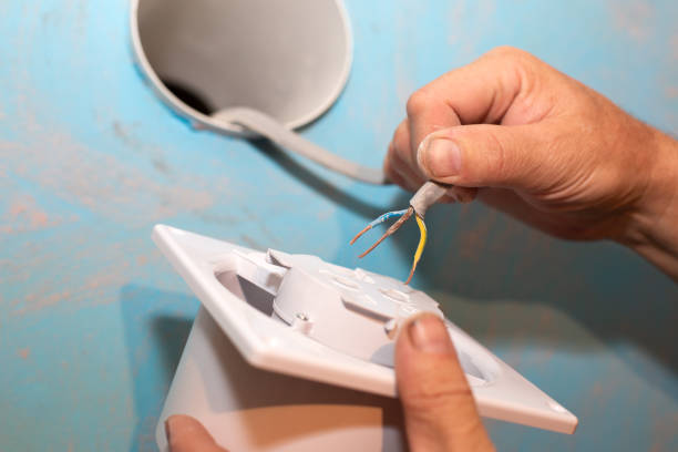 istock Man is installing the wall bathroom fan vent. Restoration process. Wires in hands. Maintenance repair works renovation in the flat. 1335935140