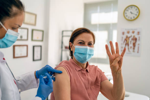 senior adult  Woman getting her fourth dose of a COVID-19 vaccination stock photo