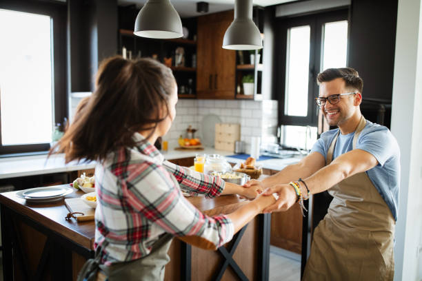 istock Beautiful couple is smiling while cooking together in the kitchen 1335937163