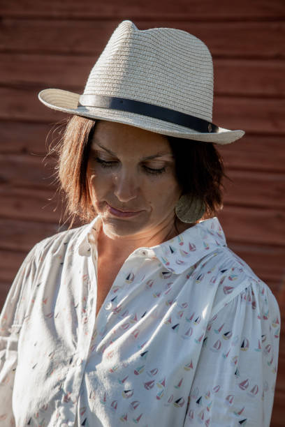 istock Woman in hat looking down 1335940038
