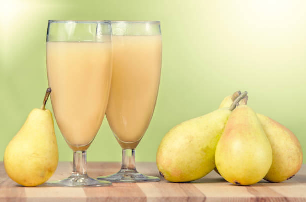 still life of pears and glasses filled with pear juice