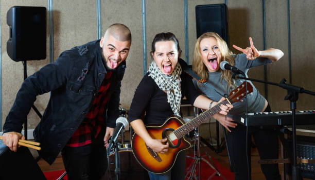 istock Three bandmates posing together with musical instruments in rehearsal room 1335941022