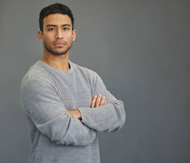 istock Shot of a handsome young man standing against a grey background 1335941246