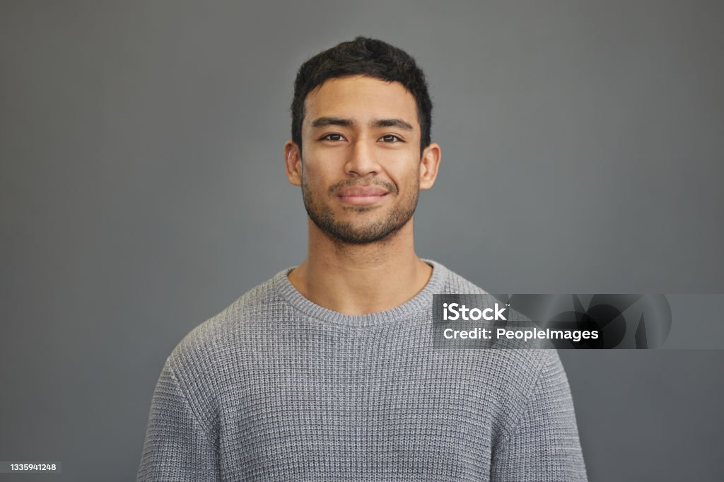 Shot of a handsome young man standing against a grey background First you have to believe in yourself Portrait Stock Photo