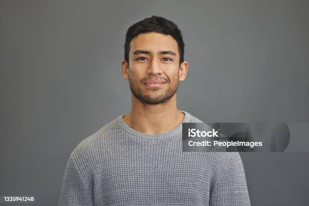 Shot Of A Handsome Young Man Standing Against A Grey Background Stock Photo - Download Image Now