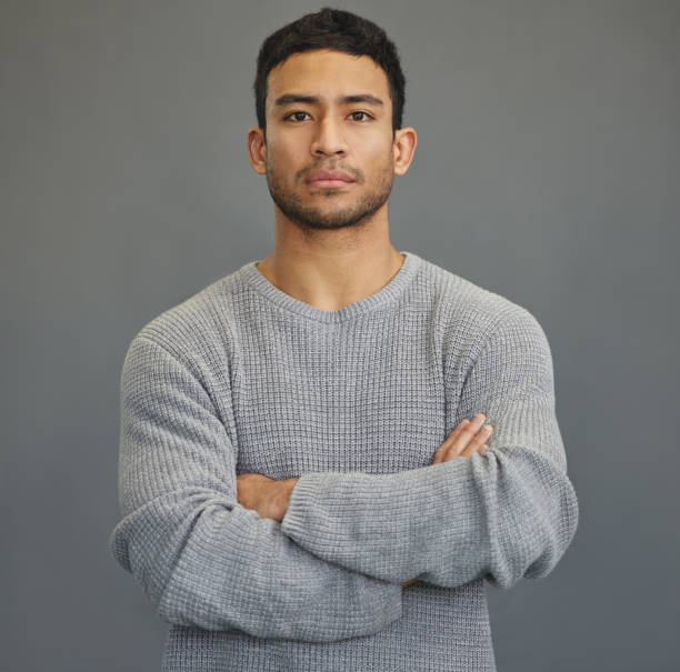 Shot of a handsome young man standing against a grey background You either win or you learn, sometimes you do both serious photos stock pictures, royalty-free photos & images