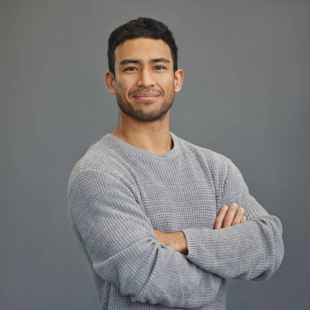 istock Shot of a handsome young man standing against a grey background 1335941253