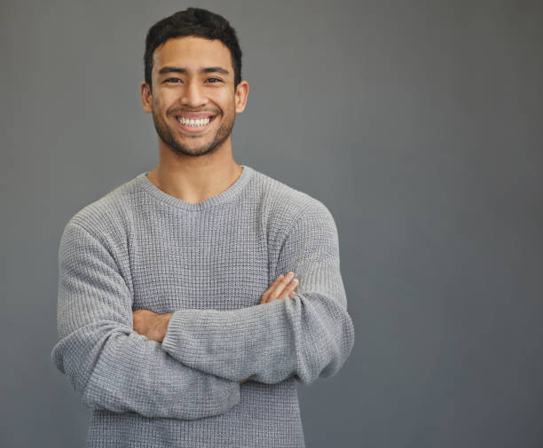 istock Shot of a handsome young man standing against a grey background 1335941256
