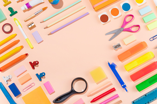 Back to school concept with crayons and school supplies on pink background