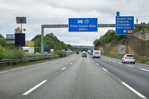 Kassel, Germany - August 16, 2021: Traffic on german Autobahn A7 nearby Kassel in Hesse. The Bundesautobahn 7 (abbreviated as BAB 7 or A 7) is the longest German Autobahn at 963 km. Highway A7 starts in the north at the border with Denmark and ends in the south at the Austrian border. Some road users in the background.