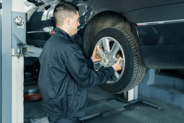 istock Car service mechanic is replacing the wheels. removing the wheel. 1335956657