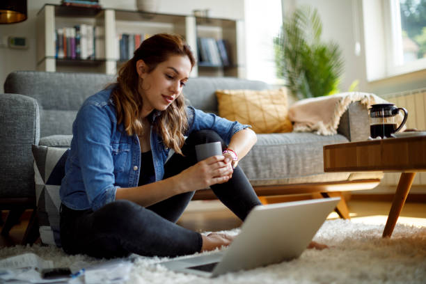 istock Young woman drinking coffee and working at home 1335957930