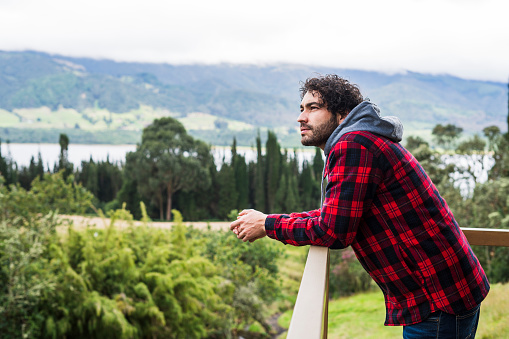 Latin man of average age 30 casually dressed walks along nature trail enjoying the scenery